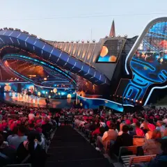 Widownia na festiwalu w Opolu, podziwiająca nowoczesną scenę w kształcie mikrofonu.