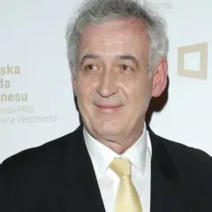 Waldemar Dąbrowski w garniturze i żółtym krawacie, z siwymi włosami, uśmiecha się. Tło z logo "Polska Rada Biznesu".