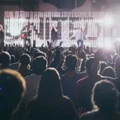 Tłum na koncercie, ręce w górze. Na scenie zespół, słychać wysoki głos kobiecy.