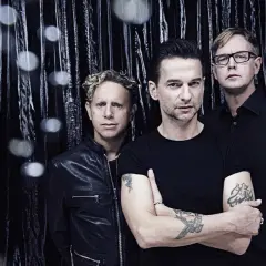 Skład Depeche Mode: Martin Gore, Dave Gahan i Andy Fletcher pozują na tle błyszczącej, czarnej kurtyny.