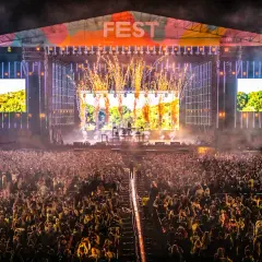 Ogromny tłum na fest festiwalu, scena rozświetlona fajerwerkami i ekranami.