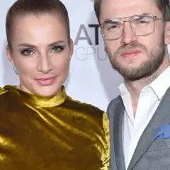 Anna Dereszowska i Maksymilian Duniak na ściance. Ona w złotej sukni, on w szarym garniturze.
