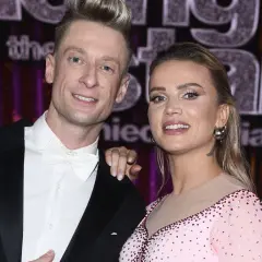 Michael Danilczuk z żoną, uśmiechnięci, pozują do zdjęcia. Ona w błyszczącej sukience, on w czarnym fraku i białej muszce.
