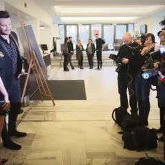 Sylwia Juszczuk z mężami pozuje do zdjęć, otoczona przez fotoreporterów.