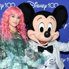 Dziewczyna z różowymi włosami i Myszka Miki pozdrawiają na tle napisu "Disney 100". Może to zapowiedź nowych piosenek Disneya?