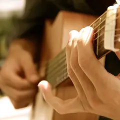 Dłonie grające na gitarze, tworząc melodię, która mogłaby być równie piękna i wzruszająca jak "Lacrimosa".