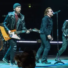 Bono śpiewa, The Edge gra na gitarze, a Adam Clayton na basie. Ich muzyka to pieśń protestu, która porusza tłumy.