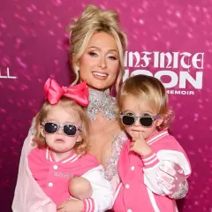Paris Hilton z dwójką uroczych dzieci, obie w różowych kurtkach i okularach przeciwsłonecznych.