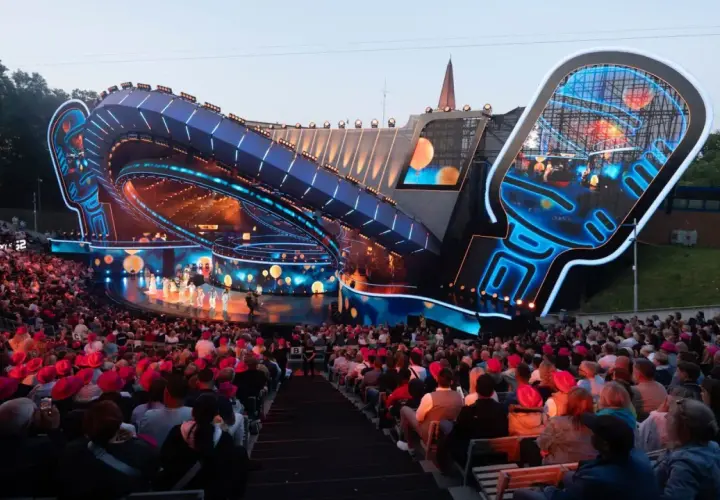 Widownia na festiwalu w Opolu, podziwiająca nowoczesną scenę w kształcie mikrofonu.