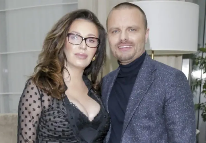 Marcin Hakiel z partnerką, uśmiechnięci, pozują do zdjęcia. Ona w okularach i czarnej, prześwitującej bluzce, on w marynarce.