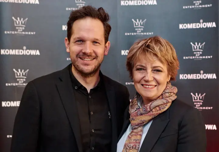 Rafał Pacześ z partnerką, uśmiechnięci na ściance.