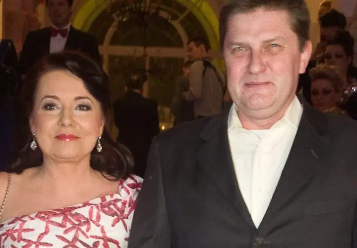 Danuta Holecka z pierwszym mężem na gali. Kobieta w białej sukni z czerwonym wzorem, mężczyzna w garniturze.