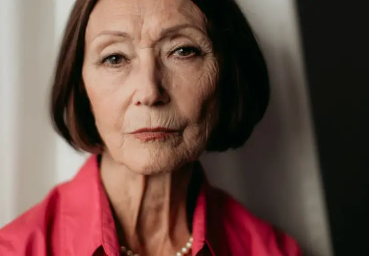 Portret starszej kobiety w różowej koszuli, z naszyjnikiem z pereł. Ewa Woydyłło-Osiatyńska, pierwsza żona, wspomina.
