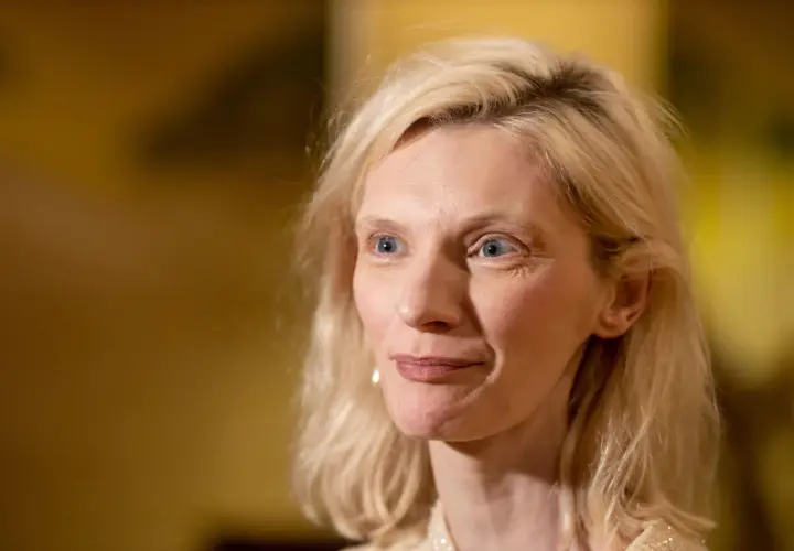 Agata Buzek zamyślona, być może wspominająca swoje dzieci. Jej spojrzenie kieruje się w bok, a na twarzy maluje się delikatny uśmiech.