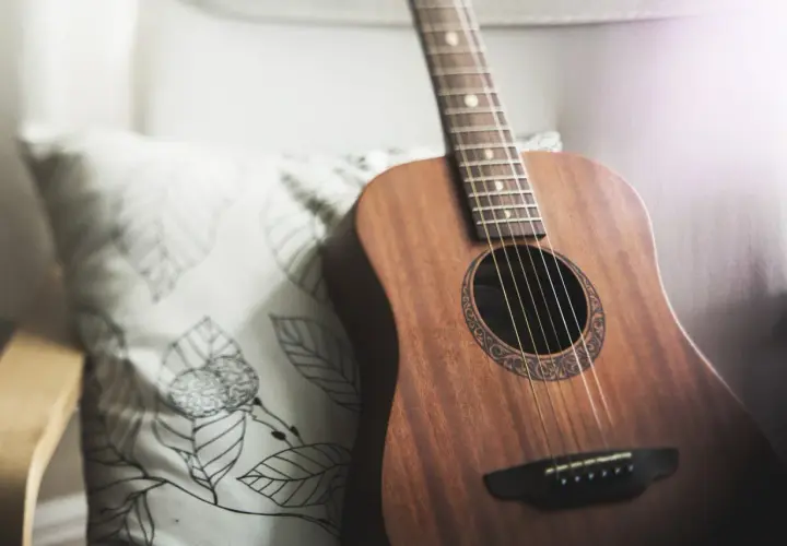 Akustyczna gitara na poduszce z liśćmi. Idealna do nauki pastorałka od serca do ucha akordy.