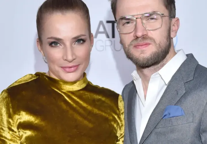 Anna Dereszowska i Maksymilian Duniak na ściance. Ona w złotej sukni, on w szarym garniturze.