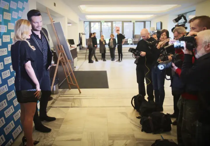 Sylwia Juszczuk z mężami pozuje do zdjęć, otoczona przez fotoreporterów.
