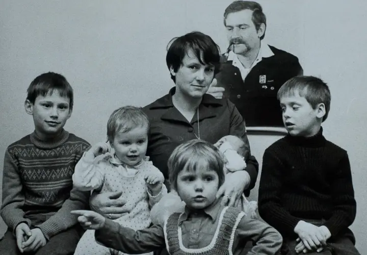 Lech Wałęsa z żoną i szóstką dzieci. Rodzina siedzi razem, widać niemowlę na rękach matki.