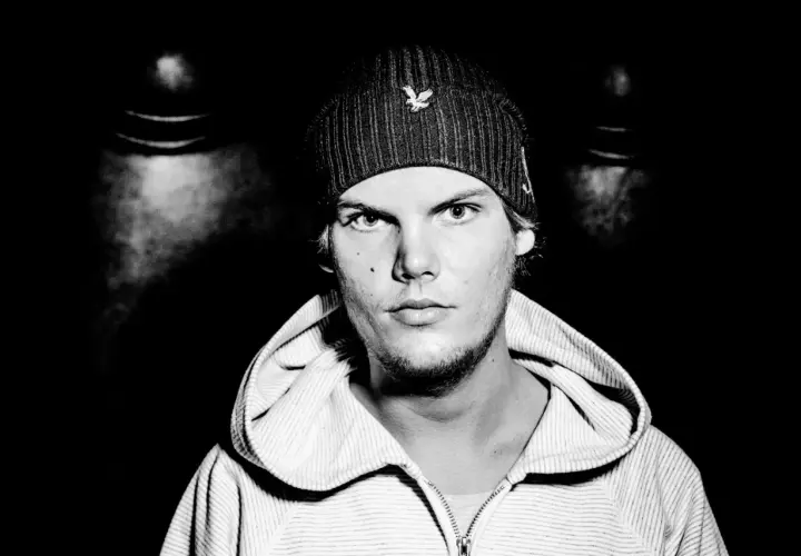Avicii, młody mężczyzna w czapce z daszkiem i bluzie z kapturem, patrzy prosto w obiektyw.