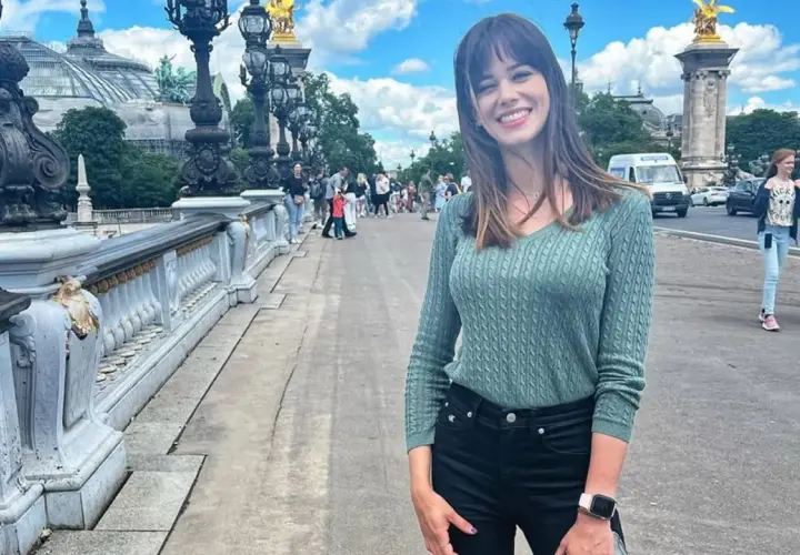 Marta Abramczyk, w wieku około 20 lat, uśmiecha się na moście w Paryżu.