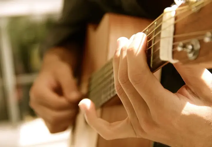 Dłonie grające na gitarze, tworząc melodię, która mogłaby być równie piękna i wzruszająca jak "Lacrimosa".