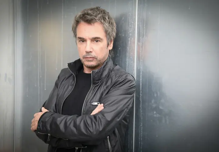 Jean-Michel Jarre, zamyślony, w czarnej kurtce, jakby czekał na swoją żonę.