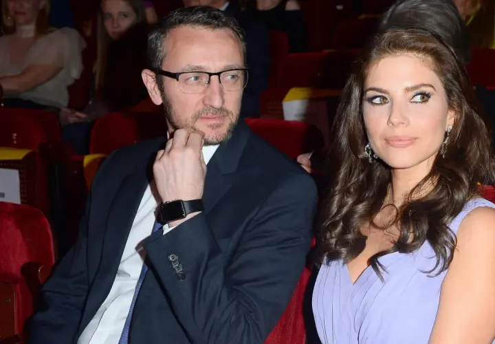 Weronika Rosati w lawendowej sukni obok partnera w garniturze, siedzą w pierwszym rzędzie.