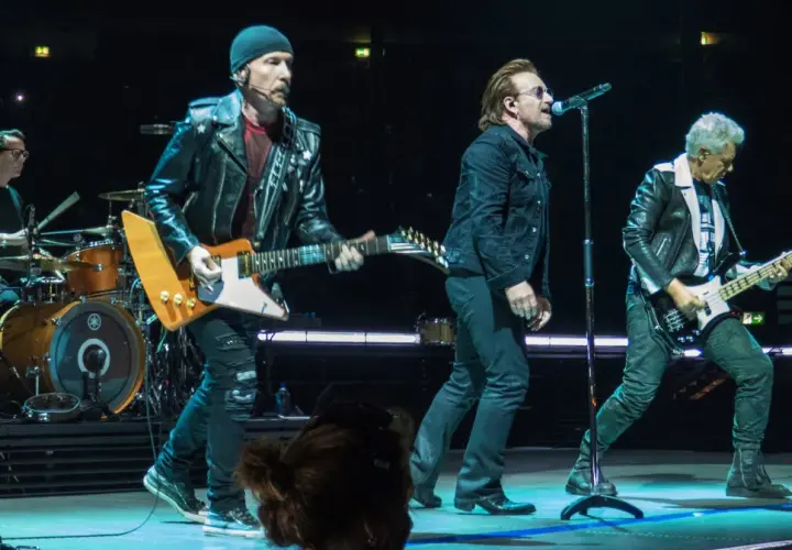 Bono śpiewa, The Edge gra na gitarze, a Adam Clayton na basie. Ich muzyka to pieśń protestu, która porusza tłumy.
