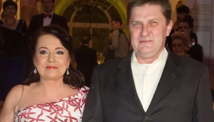 Danuta Holecka z pierwszym mężem na gali. Kobieta w białej sukni z czerwonym wzorem, mężczyzna w garniturze.