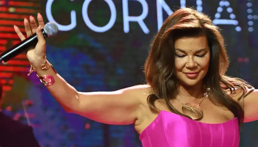 Edyta Górniak przytyła, ale nadal zachwyca na scenie w różowej kreacji, trzymając mikrofon.