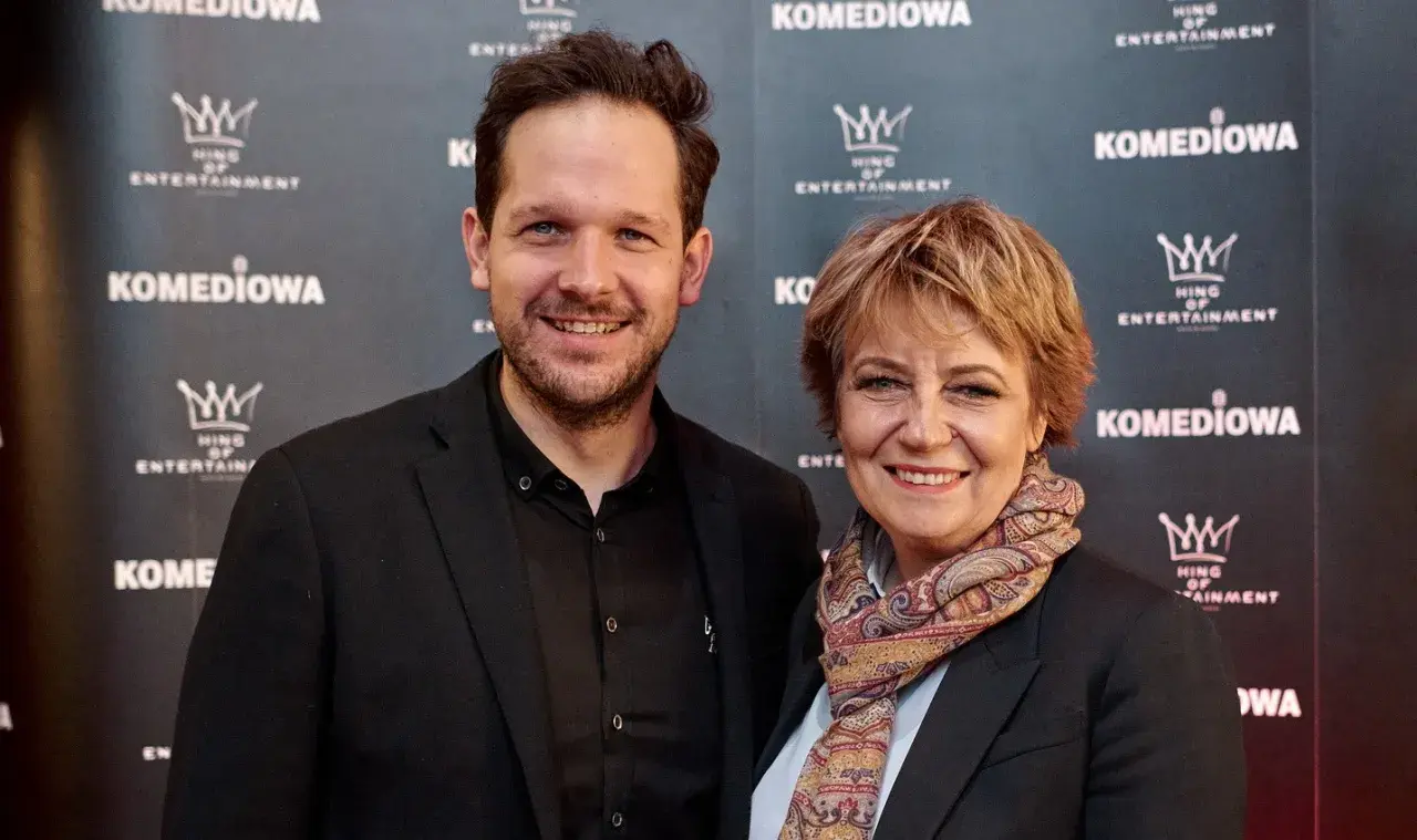 Rafał Pacześ z partnerką, uśmiechnięci na ściance.