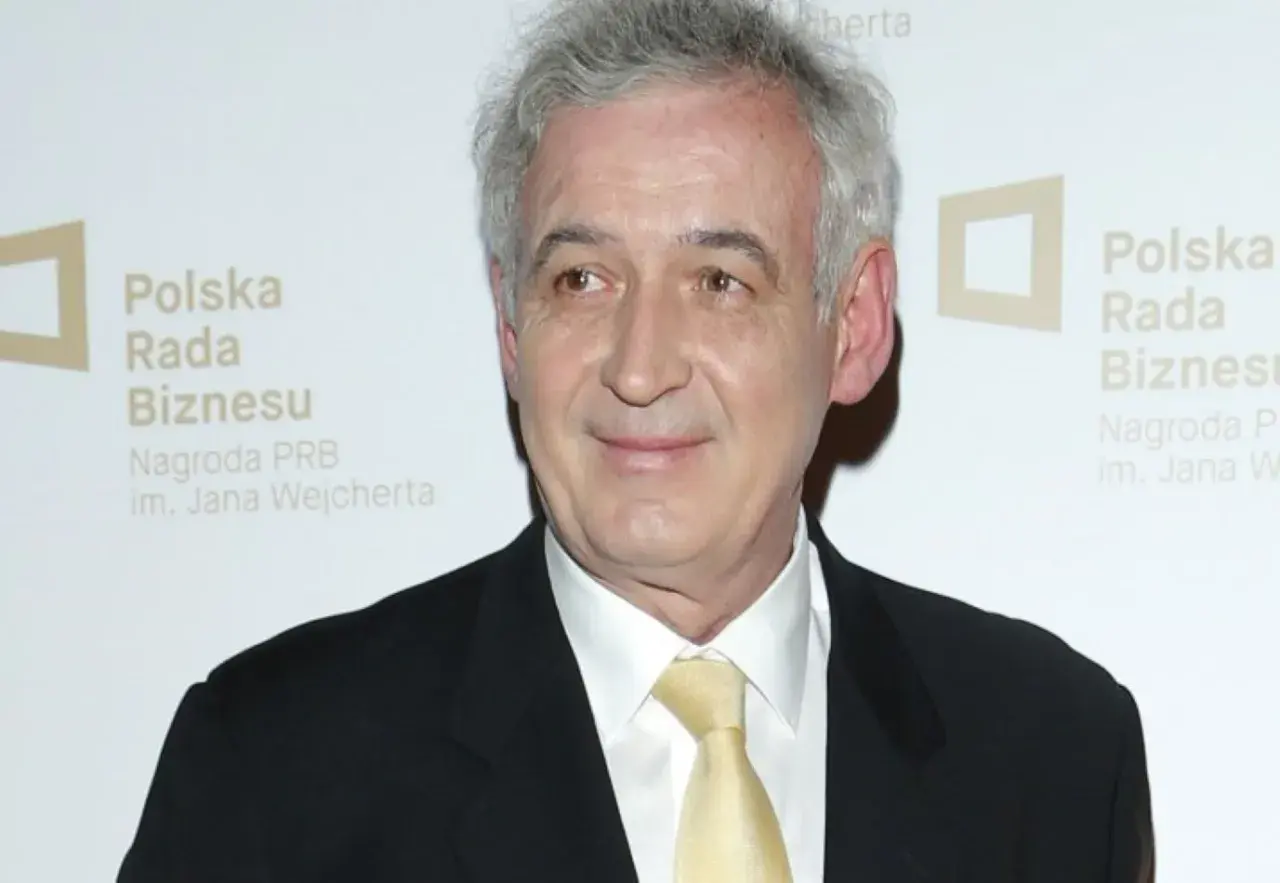 Waldemar Dąbrowski w garniturze i żółtym krawacie, z siwymi włosami, uśmiecha się. Tło z logo "Polska Rada Biznesu".