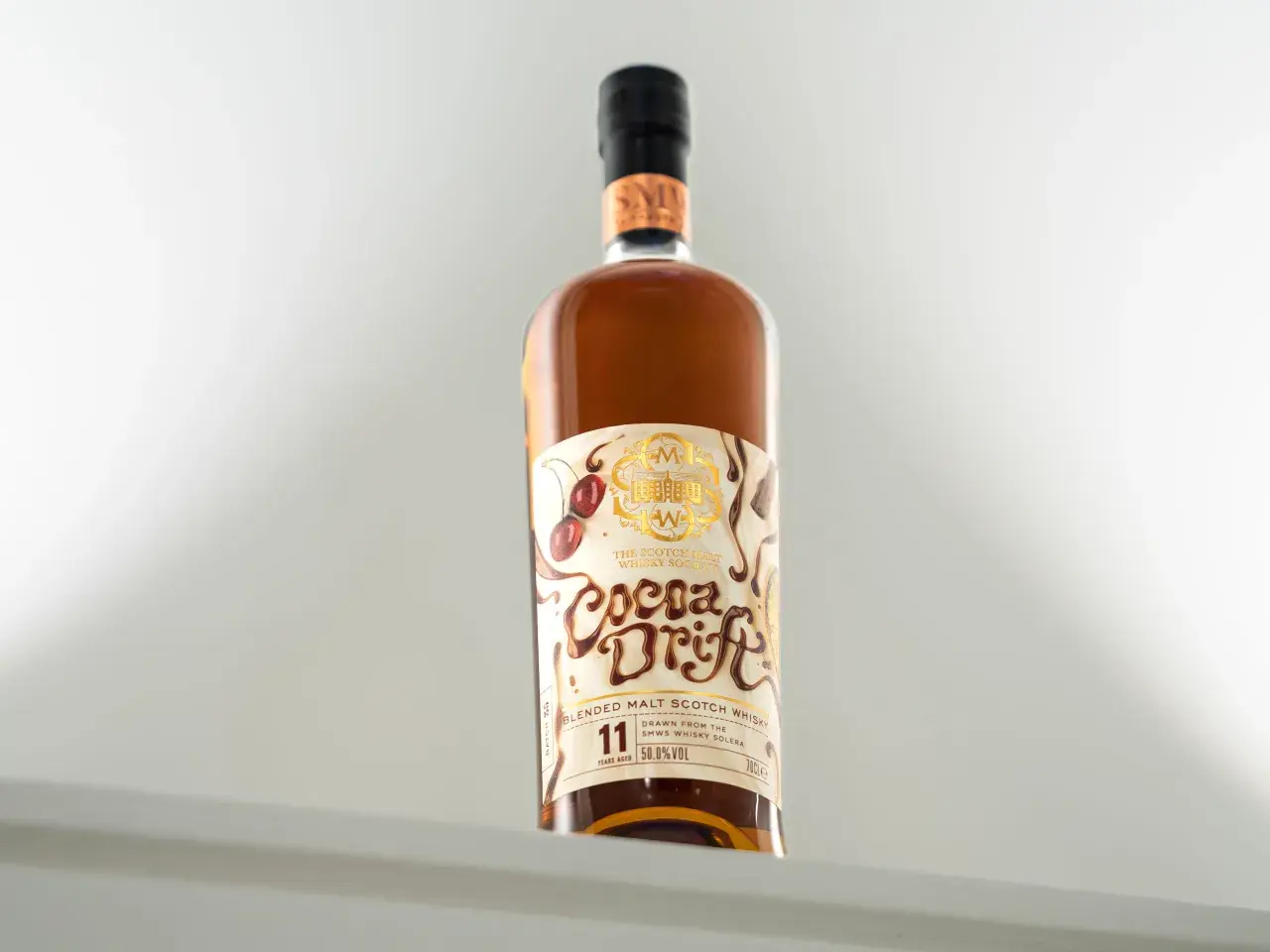 Butelka whisky "Cocoa Drift" z etykietą przedstawiającą wiśnie i czekoladę.