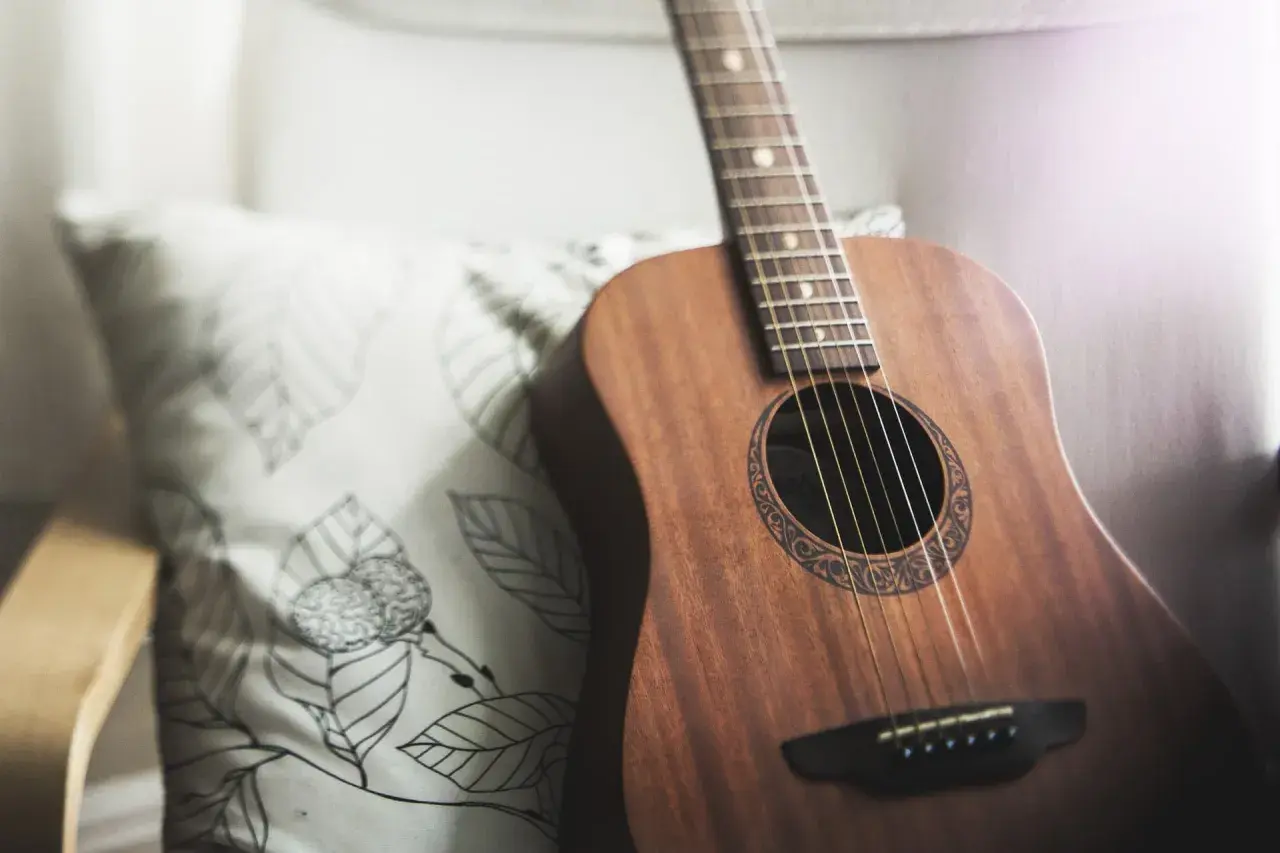 Akustyczna gitara na poduszce z liśćmi. Idealna do nauki pastorałka od serca do ucha akordy.