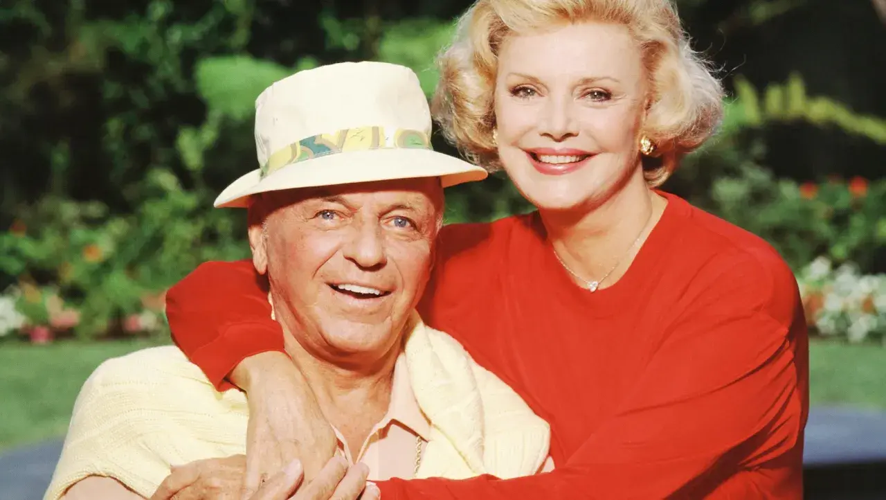 Frank Sinatra z żoną Barbarą, uśmiechnięci, w słoneczny dzień.