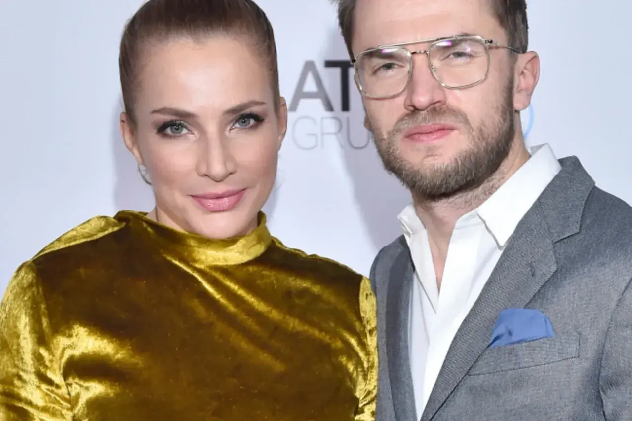Anna Dereszowska i Maksymilian Duniak na ściance. Ona w złotej sukni, on w szarym garniturze.