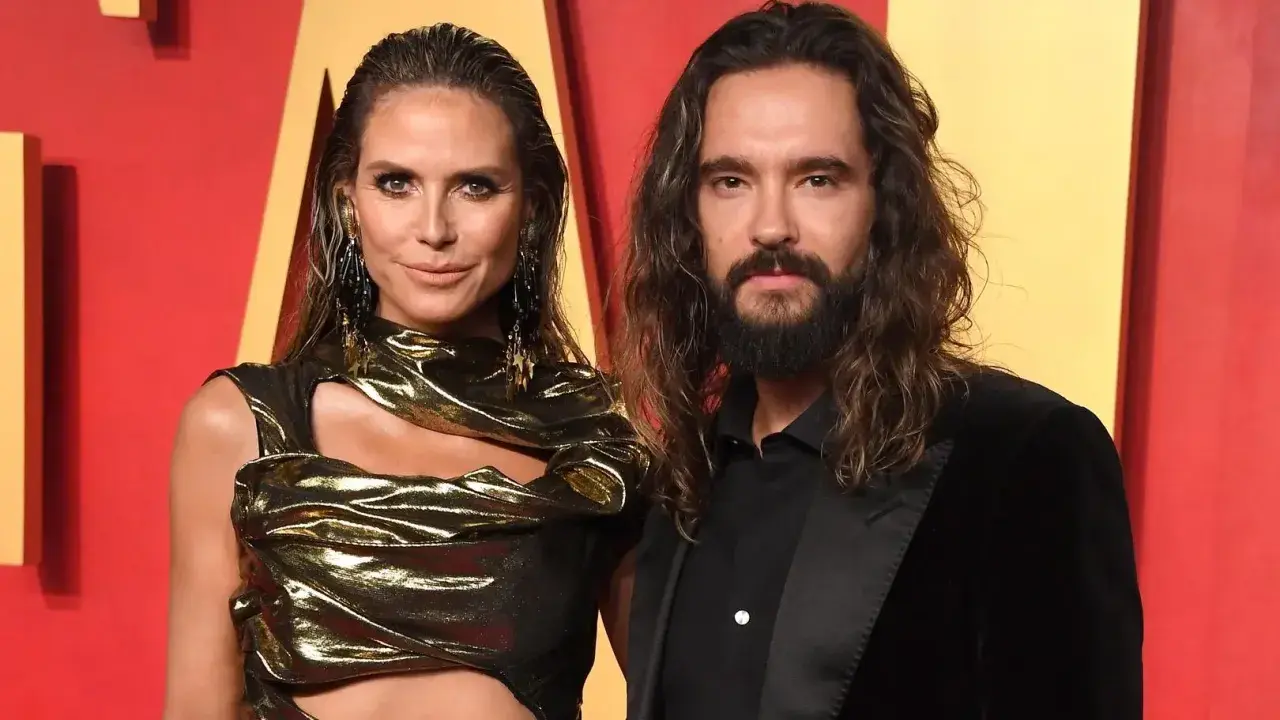Heidi Klum i Tom Kaulitz na czerwonym dywanie, ona w złotej kreacji, on w czarnym garniturze.