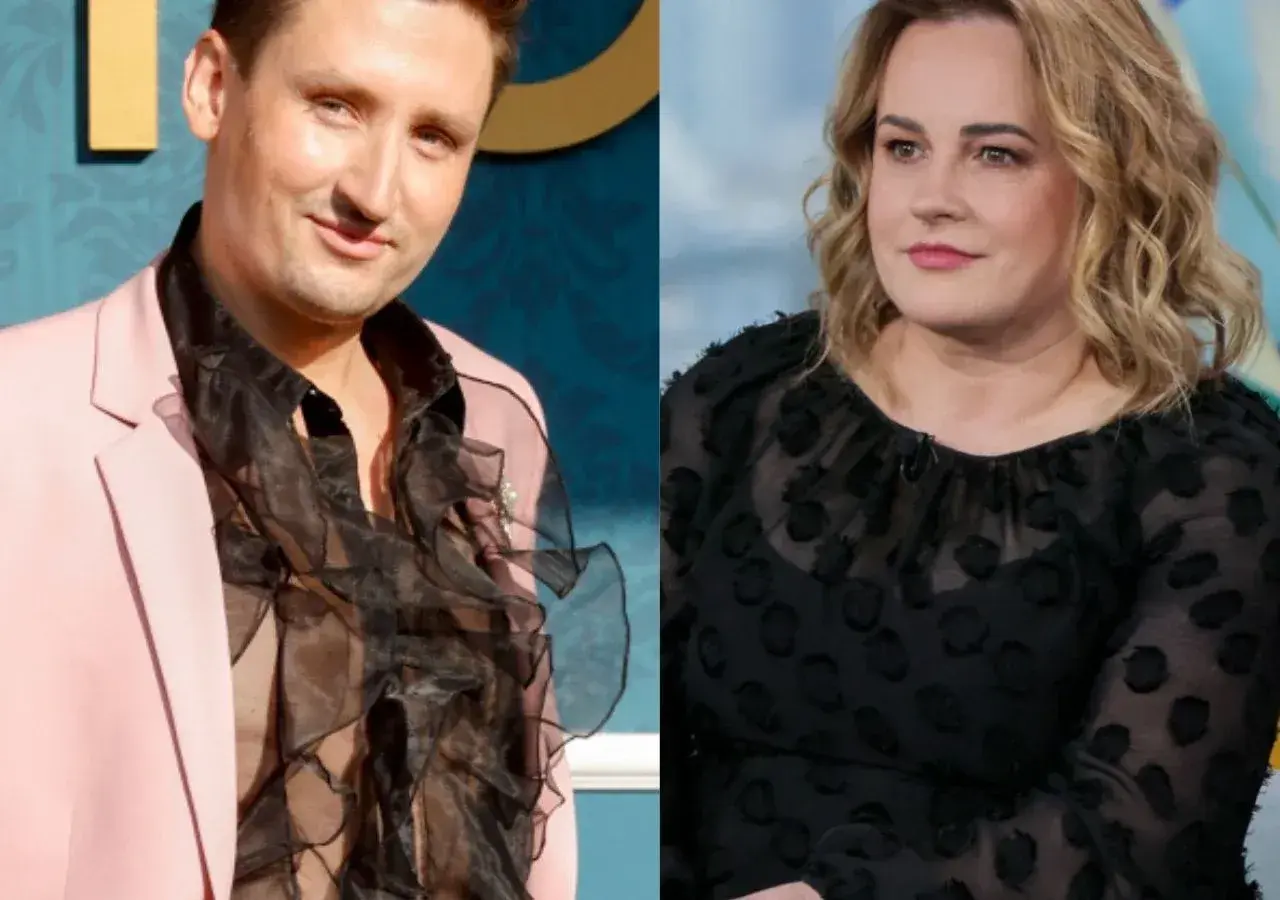 Filip Cembala, partner, w różowej marynarce i z falbaniastą koszulą, obok kobiety w czarnej bluzce.