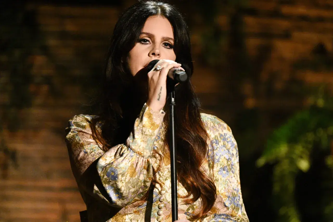 Lana Del Rey śpiewa, a jej głos unosi się w powietrzu, przypominając najpopularniejsze piosenki.