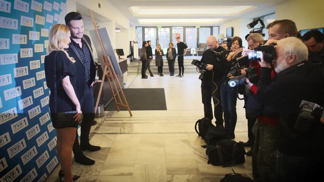 Sylwia Juszczuk z mężami pozuje do zdjęć, otoczona przez fotoreporterów.