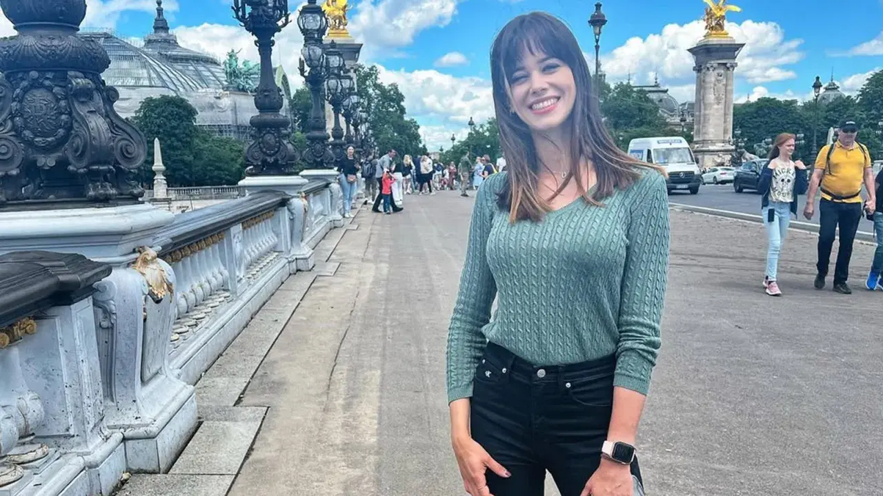 Marta Abramczyk, w wieku około 20 lat, uśmiecha się na moście w Paryżu.