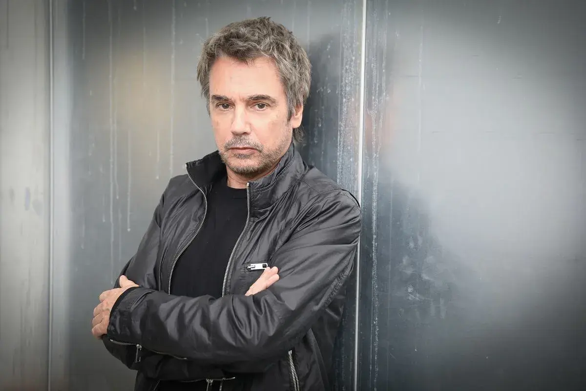 Jean-Michel Jarre, zamyślony, w czarnej kurtce, jakby czekał na swoją żonę.
