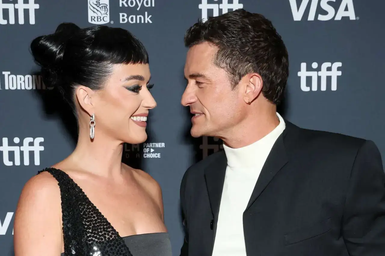 Katy Perry i Orlando Bloom patrzą na siebie z uśmiechem na czerwonym dywanie TIFF.