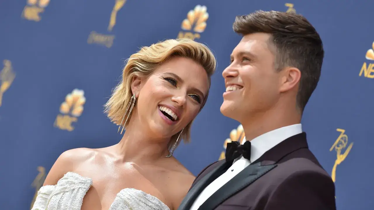 Scarlett Johansson i jej mąż Colin Jost uśmiechają się do siebie na czerwonym dywanie.