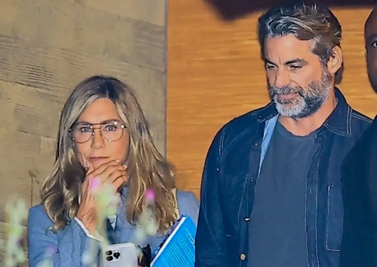 Jennifer Aniston z partnerem, w okularach, z telefonem i książką w ręku.