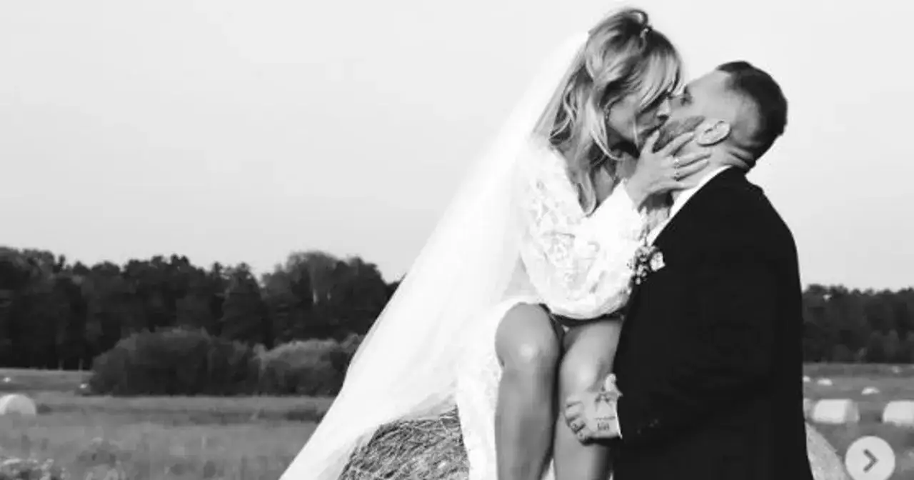 Patrycja Markowska i jej mąż w czułym uścisku na tle pola.
