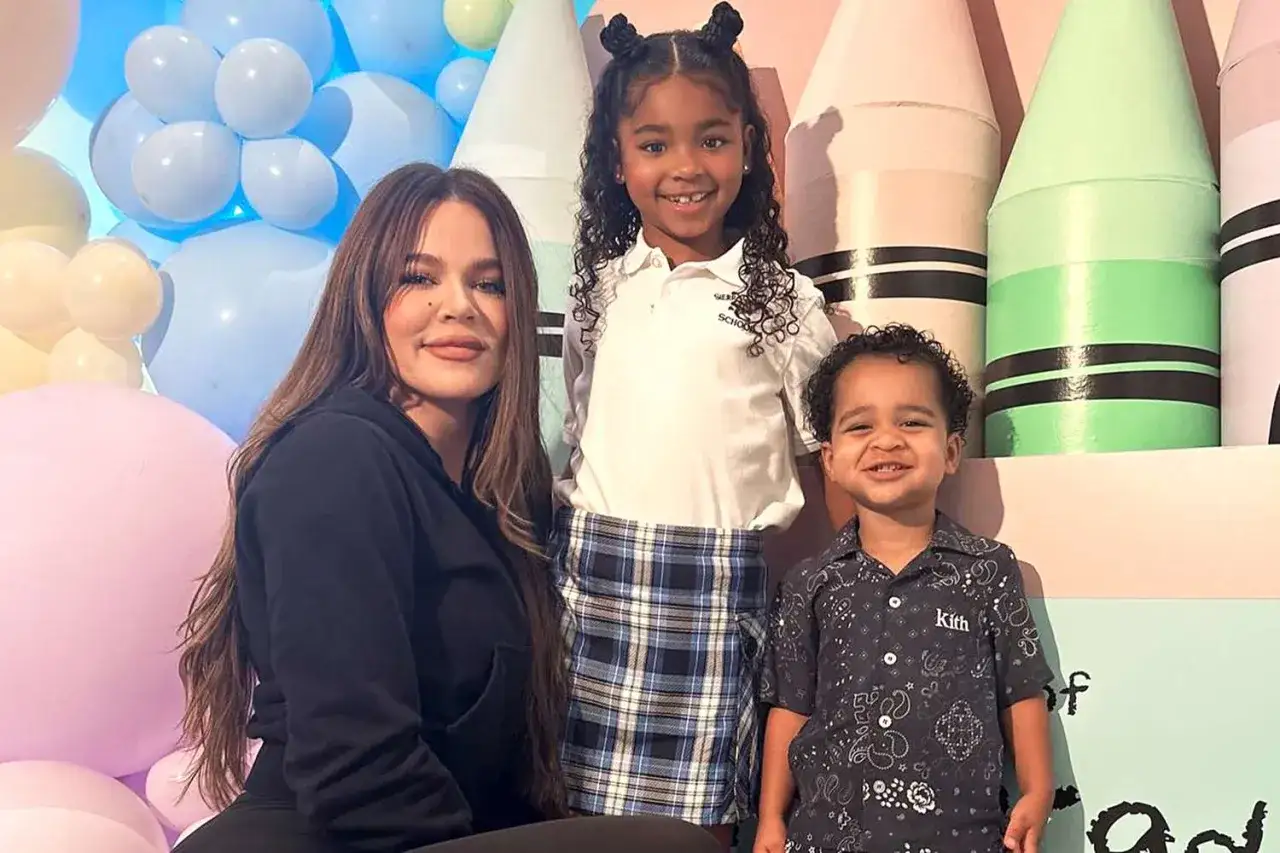 Khloe Kardashian z dziećmi, córką True i synem Tatumem, pozuje na tle kolorowych balonów i gigantycznych kredek.
